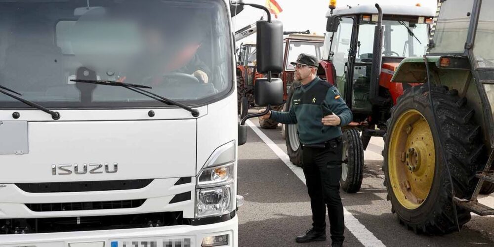 Un camionero conversa con un Guardia Civil durante la concentración de tractores en la A4. Foto: EFE/ Ismael Herrero.