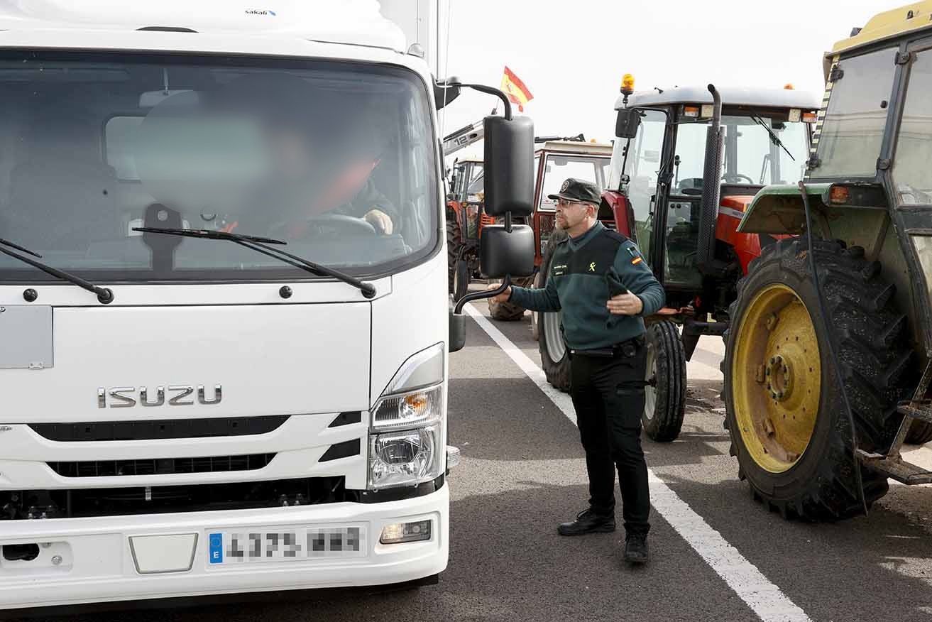 Un camionero conversa con un Guardia Civil durante la concentración de tractores en la A4. Foto: EFE/ Ismael Herrero.