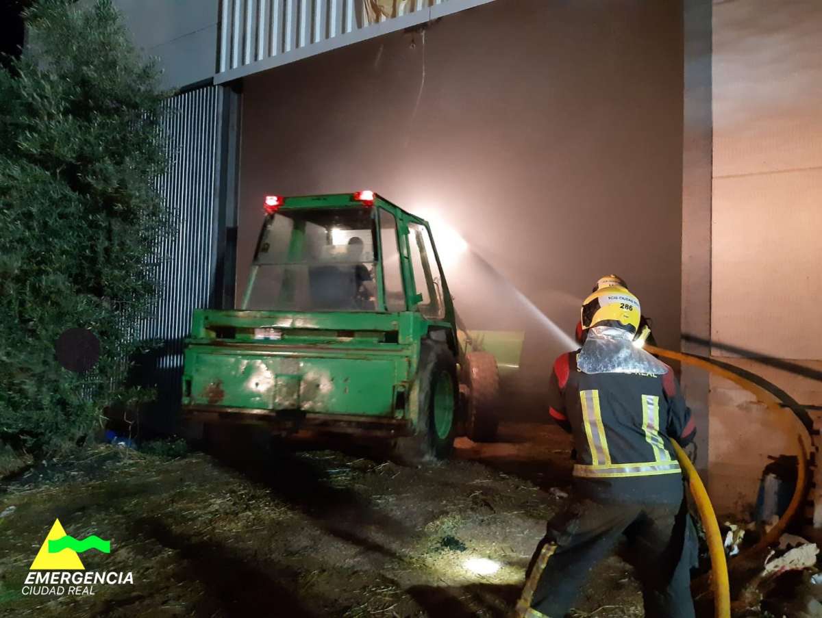 Uno de los bomberos extinguiendo las llamas del interior de la nave