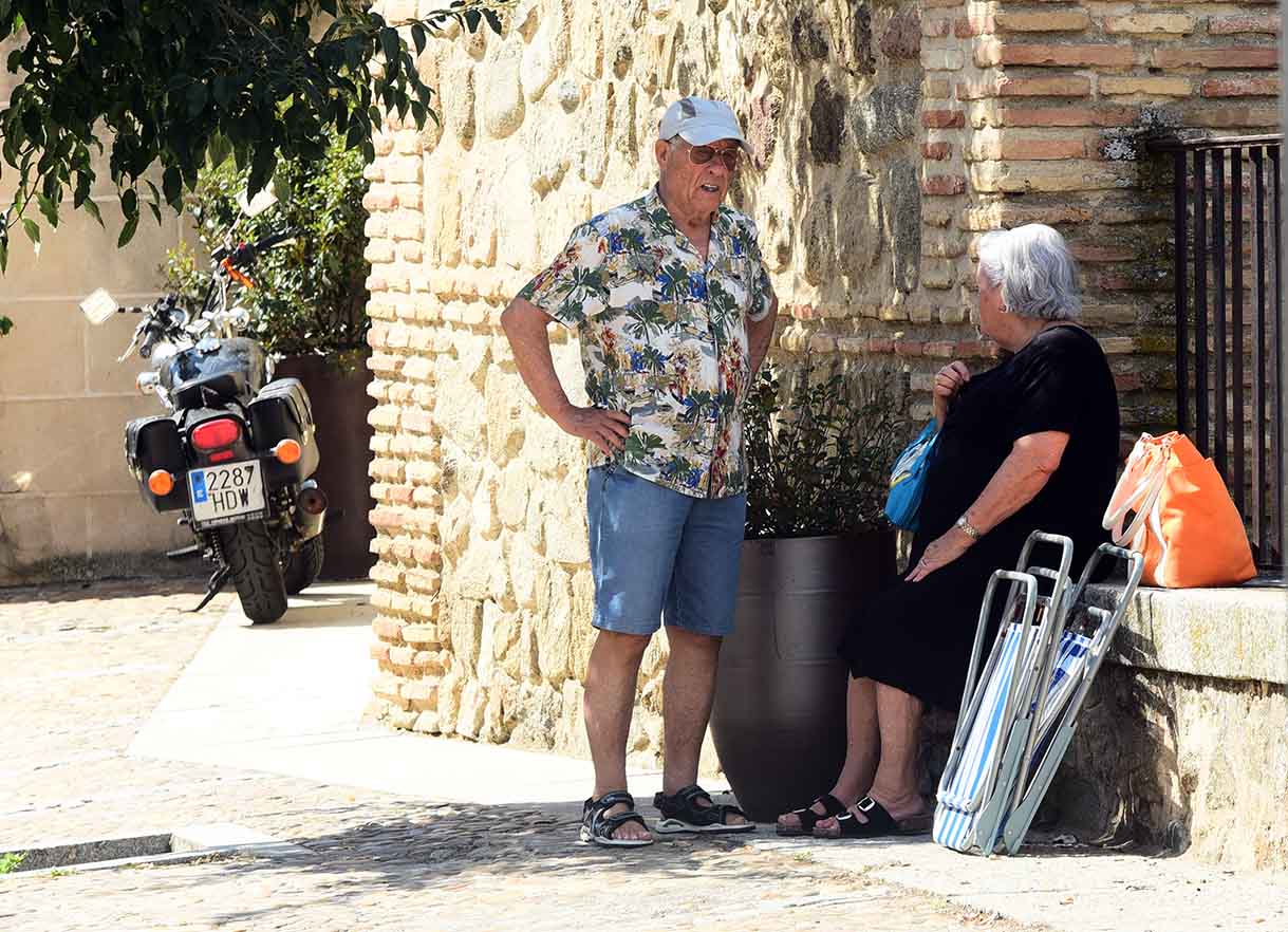 Personas mayores se refugian en una sombra del calor en Toledo