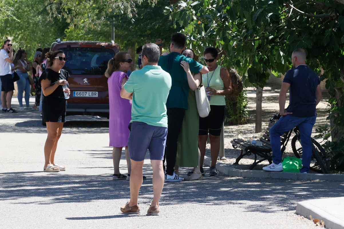 Unos vecinos hablan en la entrada al campo de fútbol de Mocejón (Toledo). Imagen EFE/Ismael Herrero.