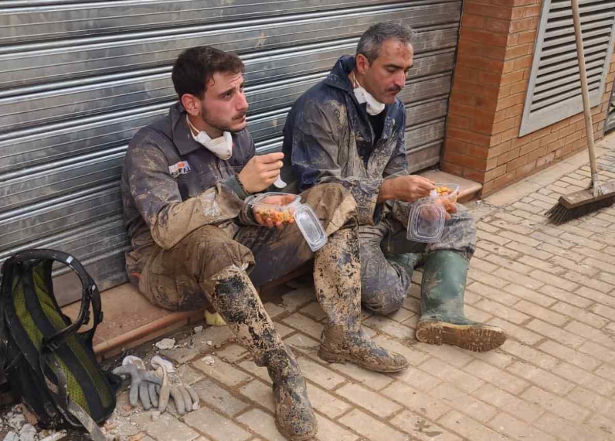 Voluntarios de Cuenca reponen fuerzas en una jornada quitando lodo en Valencia.