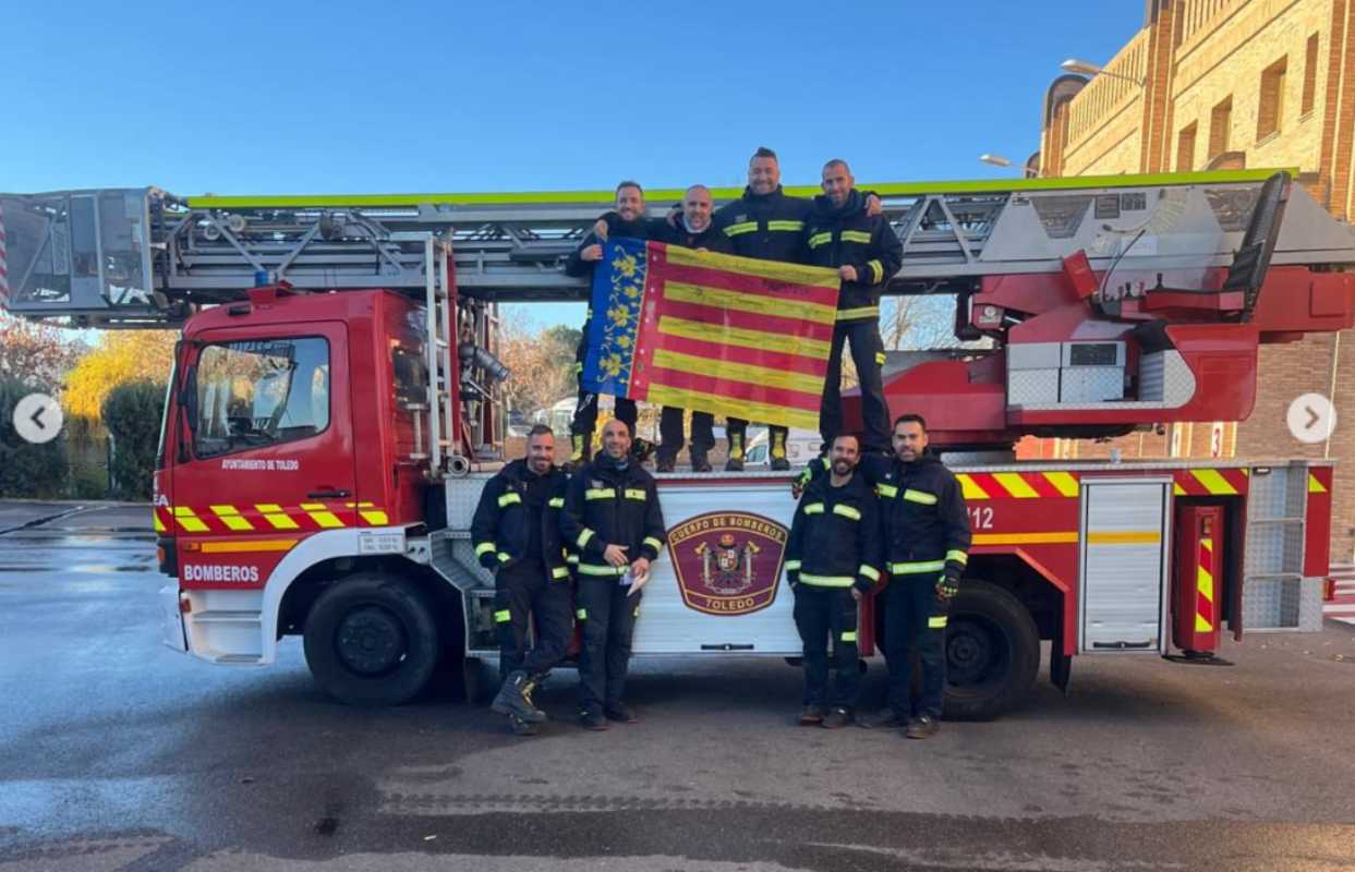 Los Bomberos de Toledo posan con la bandera que han enviado vecinos de Paiporta.