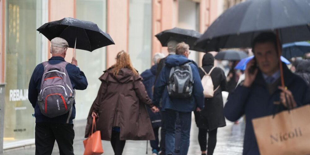 Viandantes protegiéndose de la lluvia.